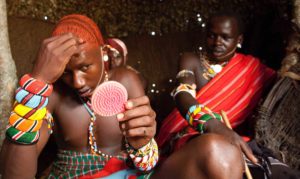Marcy Mendelson, The Samburu Story | Never without a pocket mirror, the moran's appearance takes a great amount of skill and maintenance. His natural long hair is carefully twisted and covered in ochre.