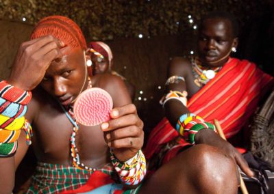 Marcy Mendelson, The Samburu Story | Never without a pocket mirror, the moran's appearance takes a great amount of skill and maintenance.  His natural long hair is carefully twisted and covered in ochre.